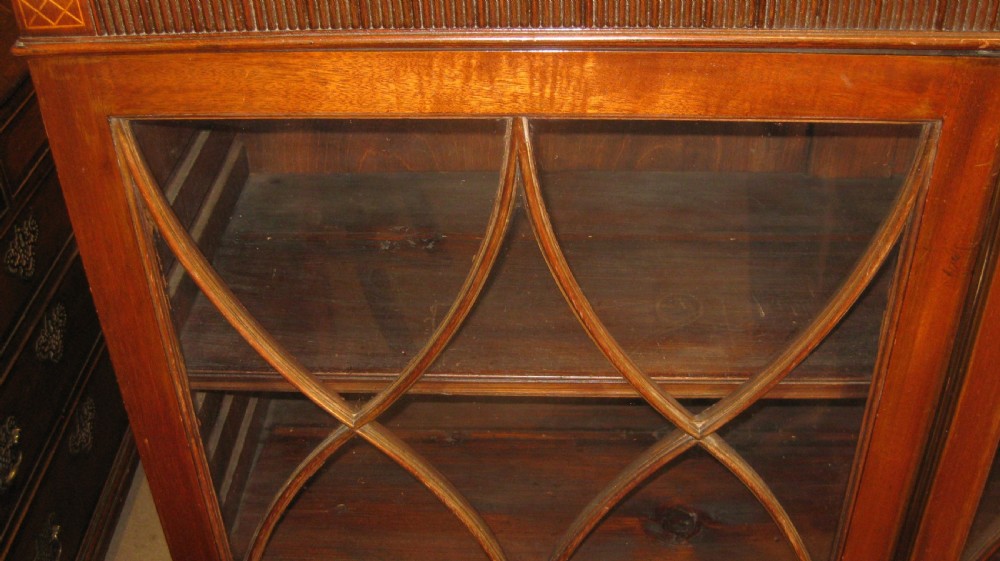 A Victorian dark mahogany glazed cabinet featuring double doors with gothic arch astragal glazing bars and bracket feet. View III