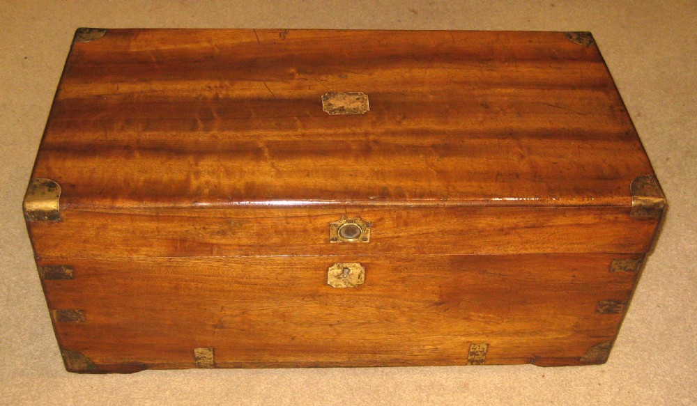 A rectangular Victorian solid camphorwood campaign trunk featuring polished brass corner mounts and central escutcheon.