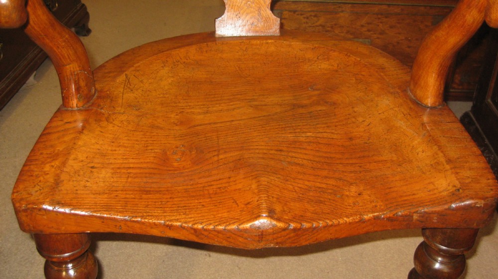 Victorian golden oak desk chair with a curved backrest, carved central splat, green leather padded seat, and turned front legs on brass castors. View XII