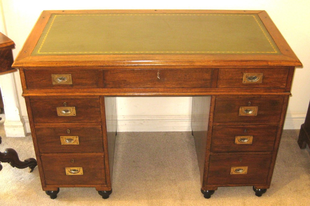 A Victorian mahogany campaign pedestal desk with a green leather top insert, recessed brass drawer pulls, and turned feet. View VI