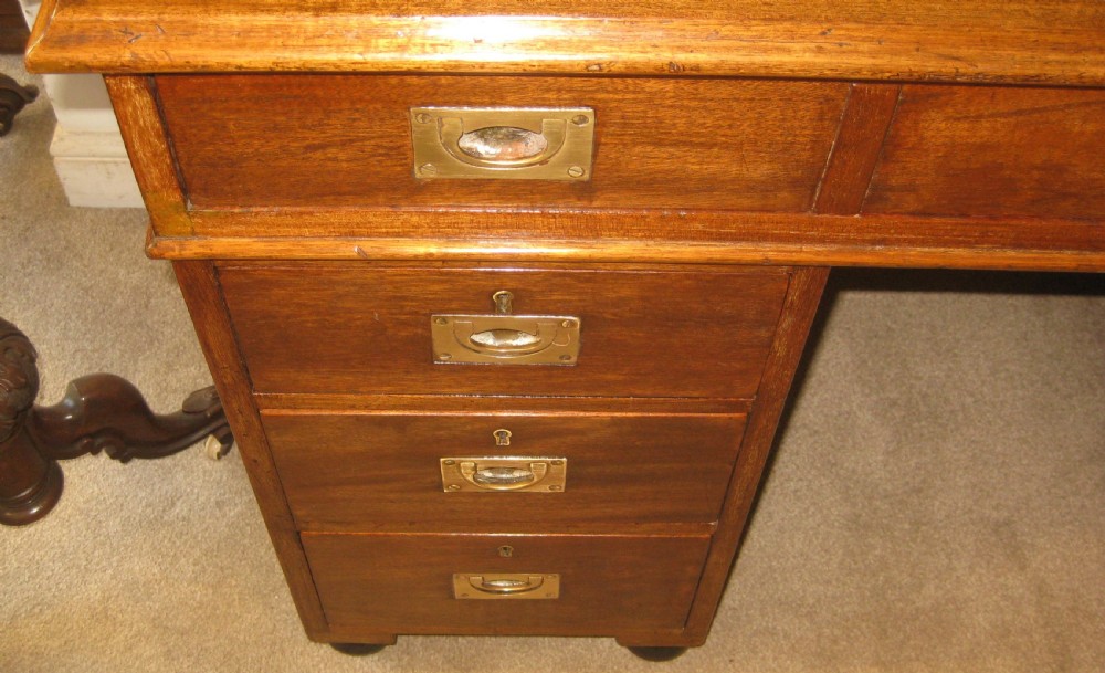 A Victorian mahogany campaign pedestal desk with a green leather top insert, recessed brass drawer pulls, and turned feet. View VII