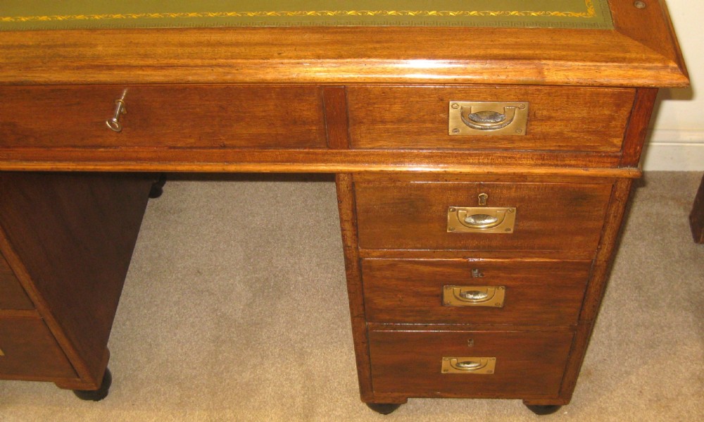 A Victorian mahogany campaign pedestal desk with a green leather top insert, recessed brass drawer pulls, and turned feet. View VIII
