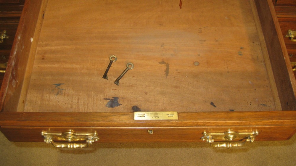 A Victorian solid walnut pedestal desk featuring a green gilt-tooled leather writing surface, nine drawers with brass drop handles, and a plinth base. View VI
