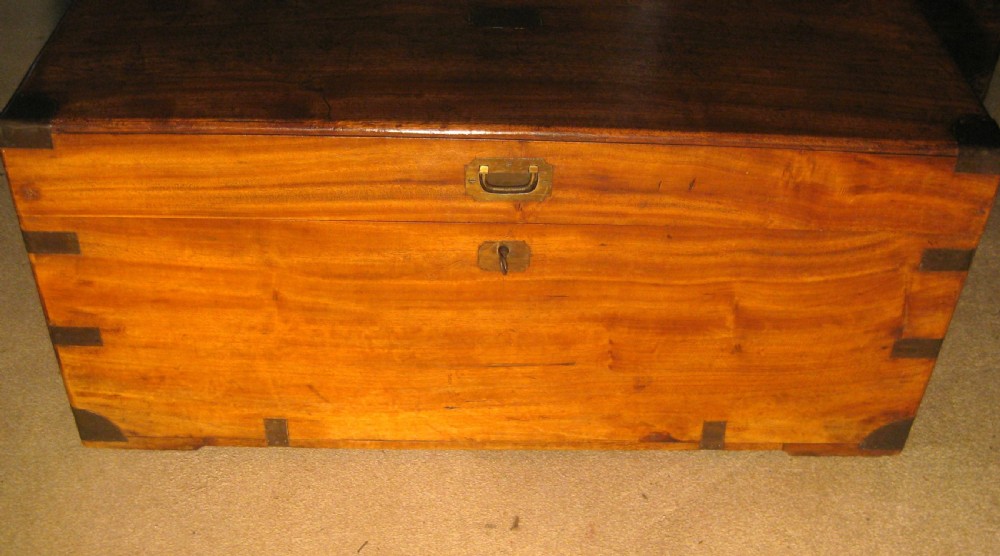 A Victorian warm brown camphorwood campaign trunk with flush brass corner straps, central lid plaque, and keyhole escutcheon. View III