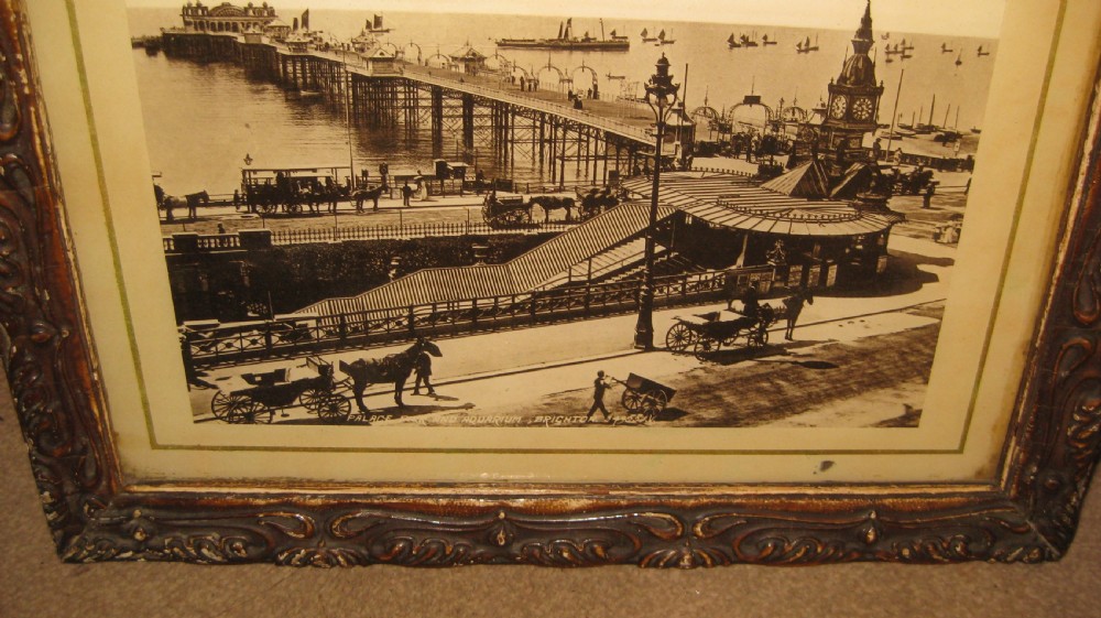 A pair of matching dark carved wooden frames containing sepia-toned historical photographs of the pier and seafront at Brighton. View II