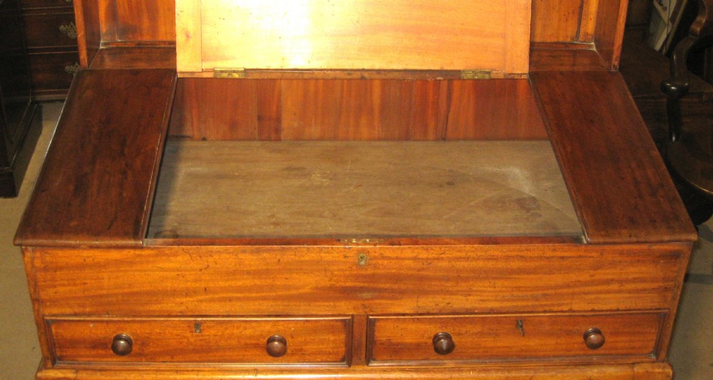 An early Victorian golden mahogany clerks desk featuring a sloped lid, upper gallery panel, two small drawers, gothic quatrefoil frieze, and turned legs. View IV