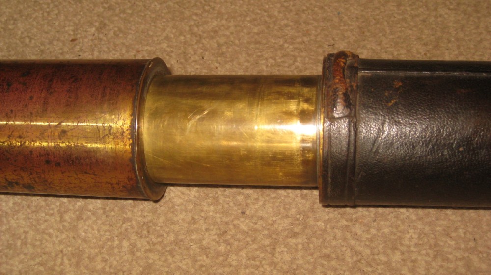 An antique brass marine telescope with an extending draw tube and a central dark leather-bound barrel. View IV