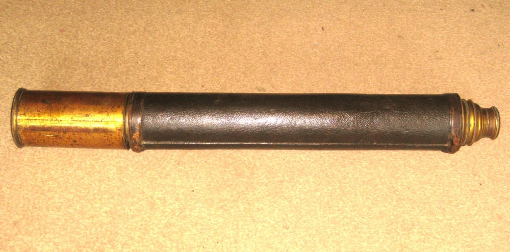 An antique brass marine telescope with an extending draw tube and a central dark leather-bound barrel. View VI