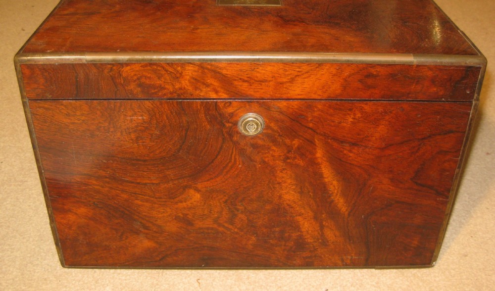 A rectangular Victorian rosewood jewellery box featuring brass edging, a central brass cartouche on the lid, and a brass keyhole escutcheon. View IV