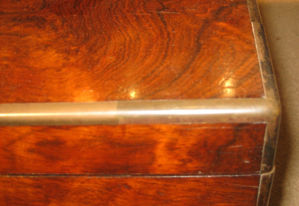 A rectangular Victorian rosewood jewellery box featuring brass edging, a central brass cartouche on the lid, and a brass keyhole escutcheon. View VI