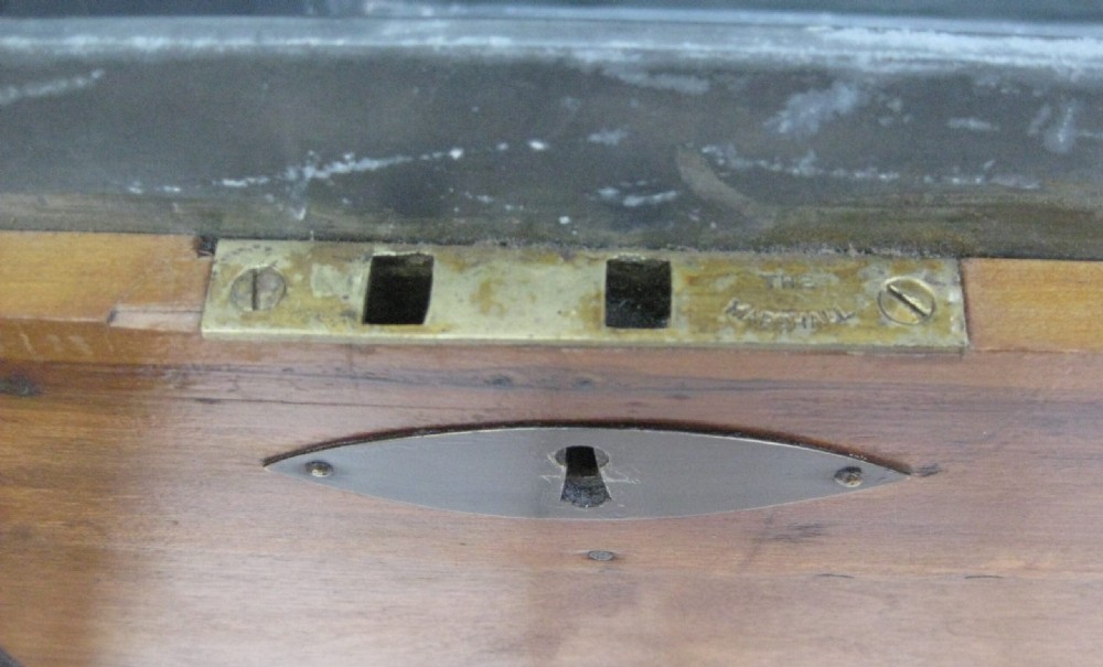 A rectangular wooden sea chest featuring black metal corner brackets, metal edge binding, and twin oval keyhole escutcheons. View III