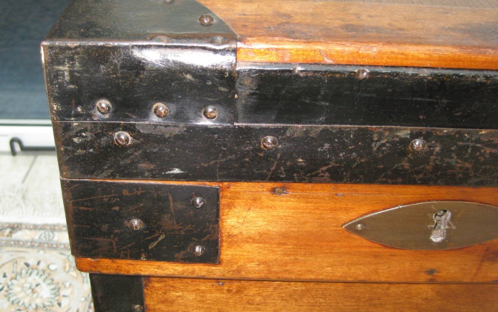 A rectangular wooden sea chest featuring black metal corner brackets, metal edge binding, and twin oval keyhole escutcheons. View VIII