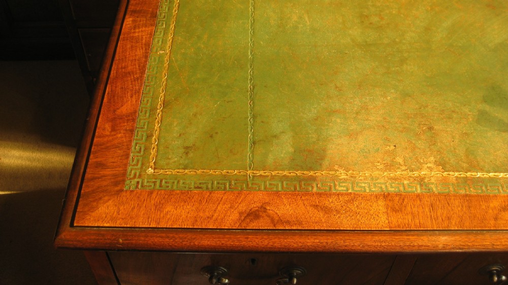 A late Victorian walnut pedestal desk featuring a leather-lined writing surface, multiple drawers with brass swan-neck handles, and carved cabriole feet. View II