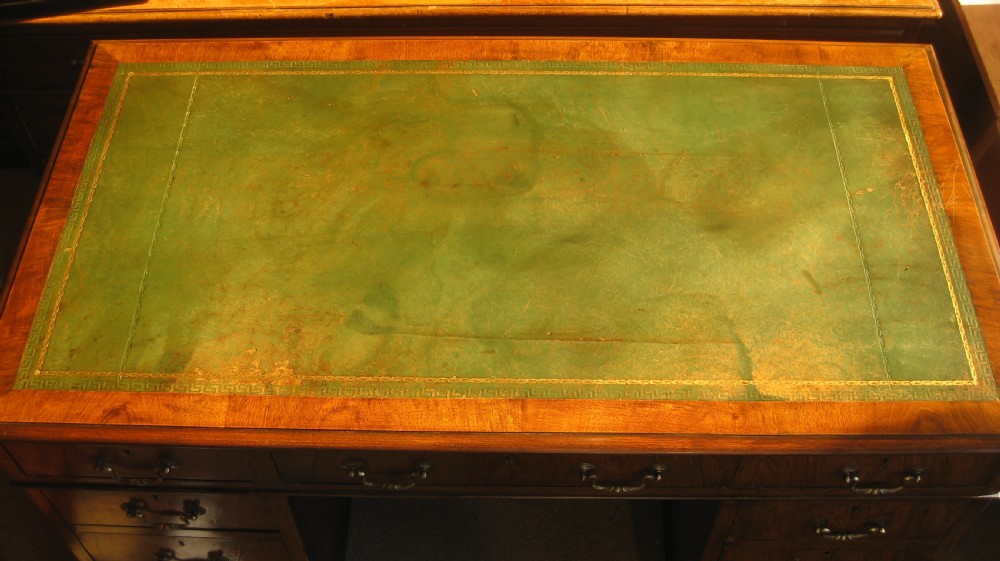 A late Victorian walnut pedestal desk featuring a leather-lined writing surface, multiple drawers with brass swan-neck handles, and carved cabriole feet. View III
