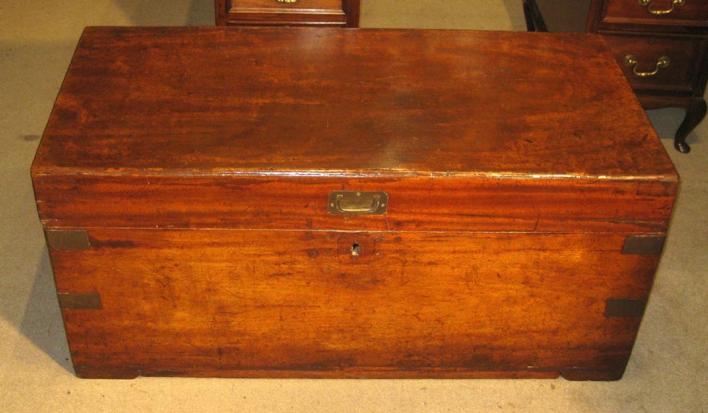 A rectangular Victorian solid camphorwood campaign trunk featuring flush brass corner straps, a brass carrying handle, and a keyhole escutcheon.