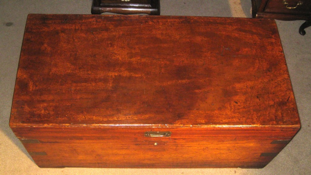 A rectangular Victorian solid camphorwood campaign trunk featuring flush brass corner straps, a brass carrying handle, and a keyhole escutcheon. View II