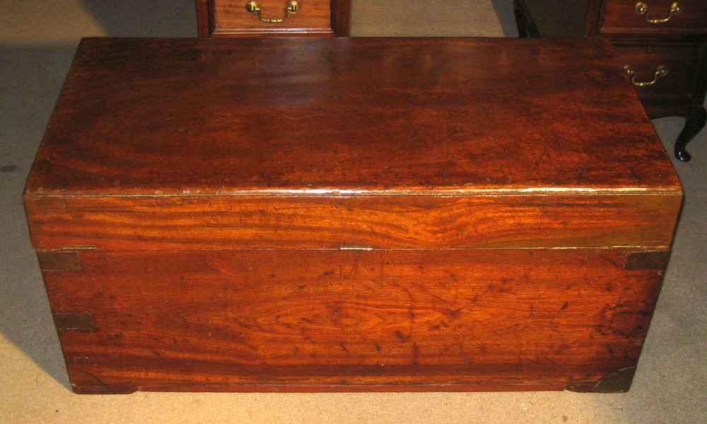 A rectangular Victorian solid camphorwood campaign trunk featuring flush brass corner straps, a brass carrying handle, and a keyhole escutcheon. View V