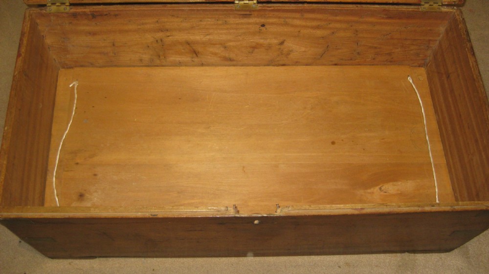 A rectangular Victorian solid camphorwood campaign trunk featuring flush brass corner straps, a brass carrying handle, and a keyhole escutcheon. View VII