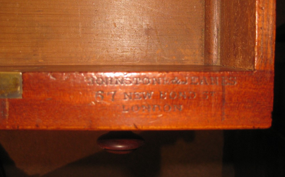 Victorian flame mahogany kneehole desk featuring multiple side drawers with turned wooden knobs and a central recessed cupboard on a plinth base. View VI