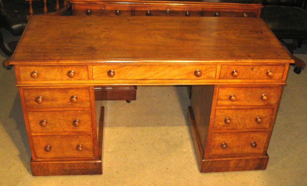 A Victorian mahogany pedestal desk featuring nine drawers with turned wooden handles and a central kneehole.