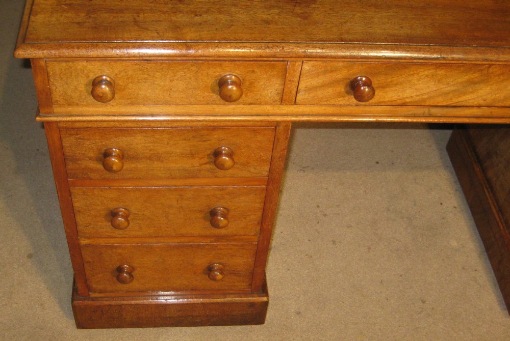 A Victorian mahogany pedestal desk featuring nine drawers with turned wooden handles and a central kneehole. View II