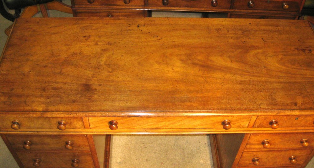 A Victorian mahogany pedestal desk featuring nine drawers with turned wooden handles and a central kneehole. View III