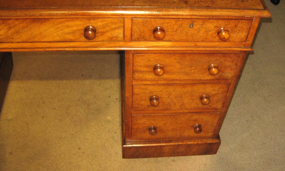 A Victorian mahogany pedestal desk featuring nine drawers with turned wooden handles and a central kneehole. View IV