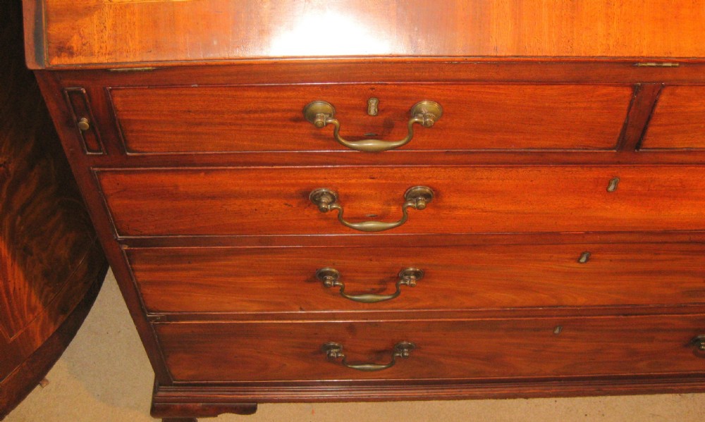 A Georgian mahogany fall-front bureau desk with crossbanded inlay, brass swan-neck handles, multiple drawers, and bracket feet. View II