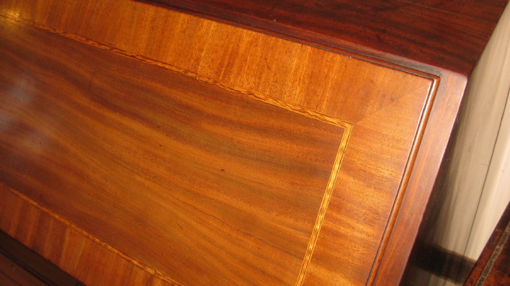 A Georgian mahogany fall-front bureau desk with crossbanded inlay, brass swan-neck handles, multiple drawers, and bracket feet. View III