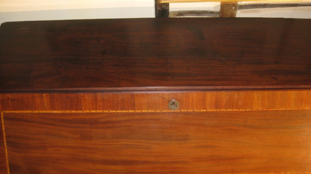 A Georgian mahogany fall-front bureau desk with crossbanded inlay, brass swan-neck handles, multiple drawers, and bracket feet. View IV
