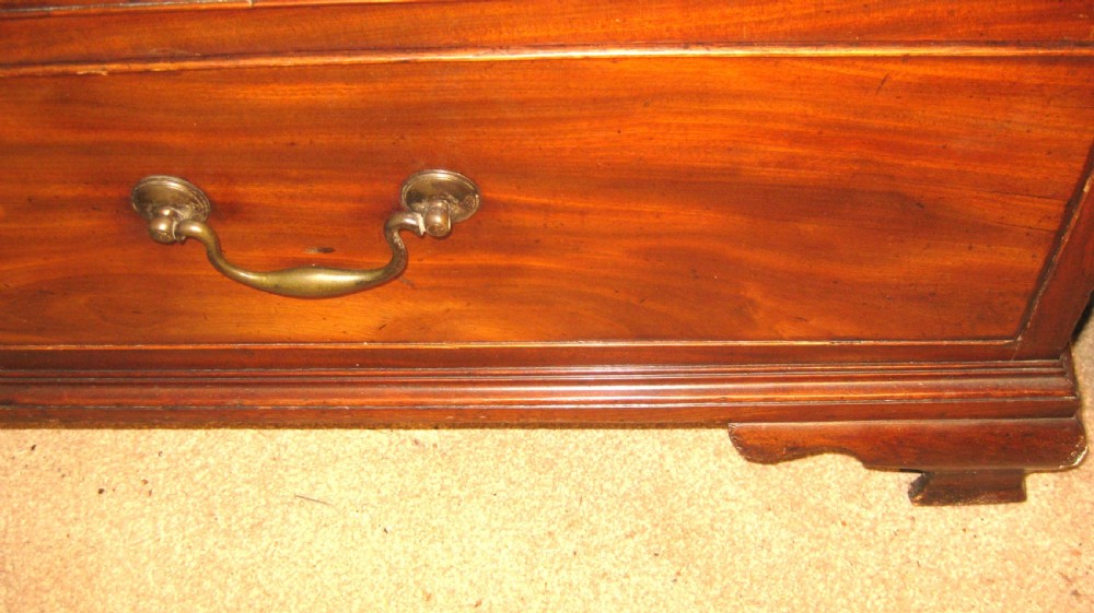 A Georgian mahogany fall-front bureau desk with crossbanded inlay, brass swan-neck handles, multiple drawers, and bracket feet. View IX
