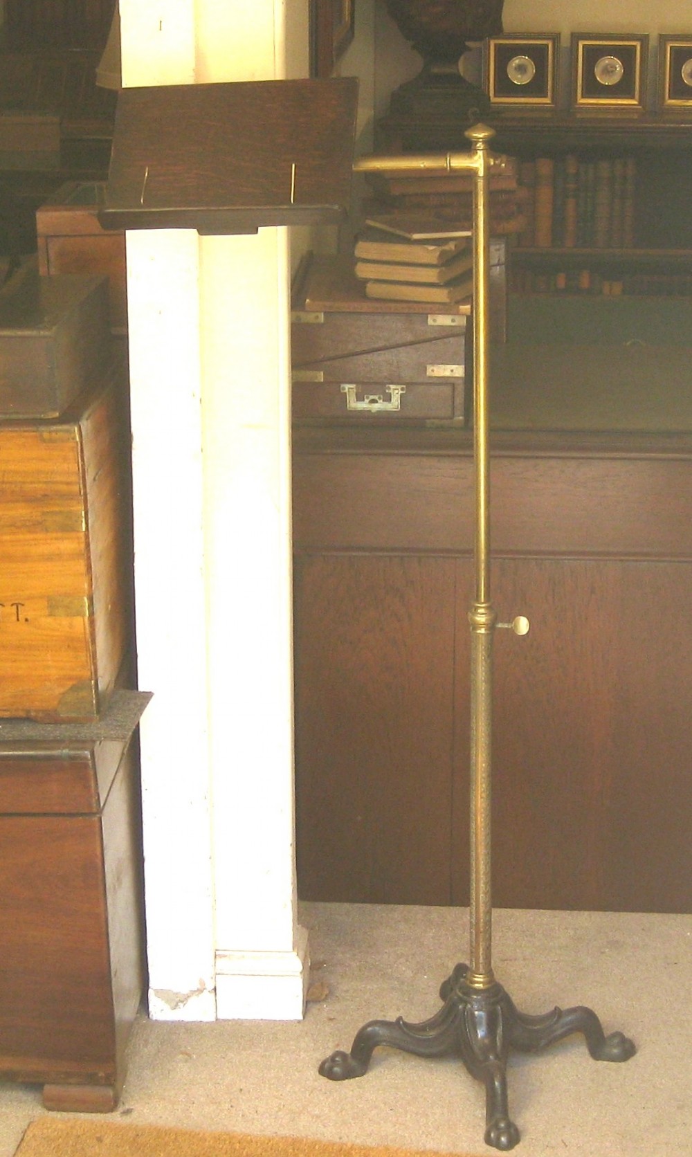 An Edwardian oak book rest mounted on an adjustable brass column with a weighted cast iron base.