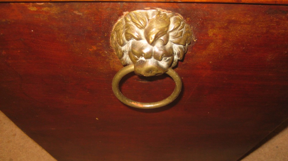 A Georgian mahogany sarcophagus-shaped wine cooler featuring a hinged stepped lid, brass keyhole escutcheon, and turned bun feet. View V