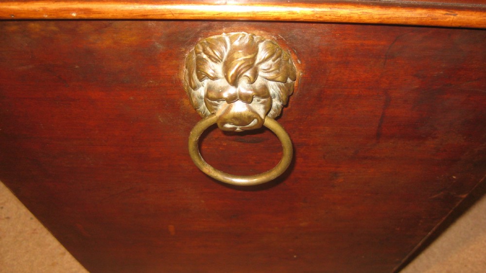 A Georgian mahogany sarcophagus-shaped wine cooler featuring a hinged stepped lid, brass keyhole escutcheon, and turned bun feet. View VII