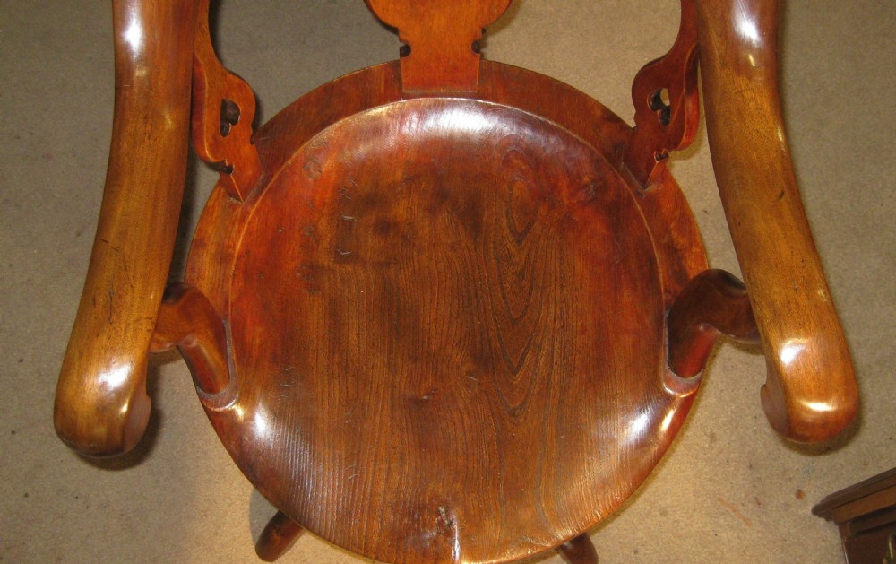 A Victorian solid mahogany revolving desk chair featuring curved continuous arms, pierced back splats, a contoured wooden seat, and four splayed cabriole legs. View VI