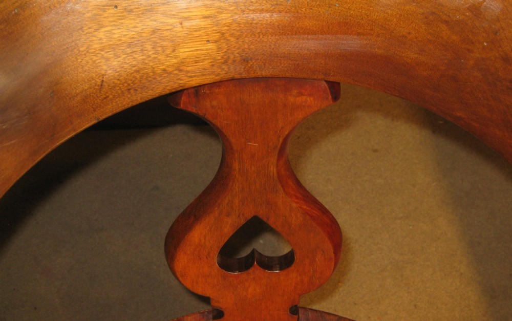 A Victorian solid mahogany revolving desk chair featuring curved continuous arms, pierced back splats, a contoured wooden seat, and four splayed cabriole legs. View XII