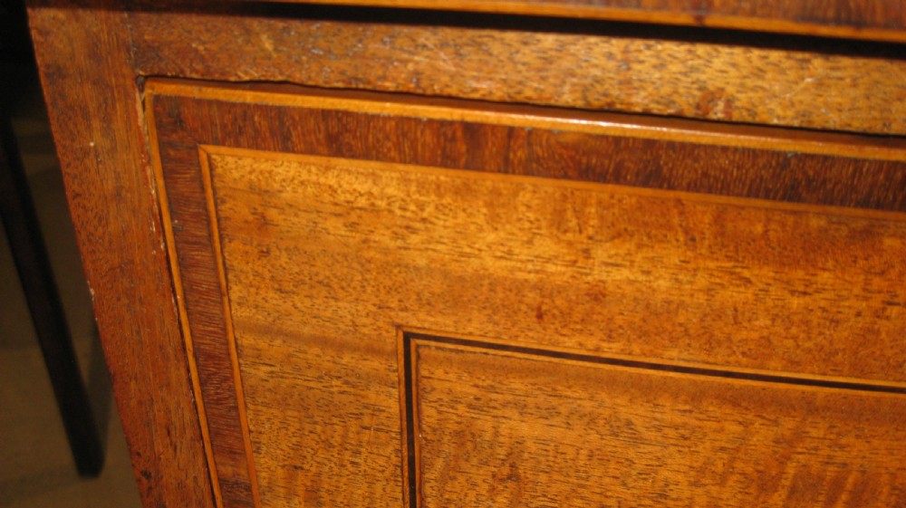 An early Georgian golden mahogany bow-fronted chest of drawers featuring two short drawers over two long drawers with brass knobs and inlaid crossbanding. View II
