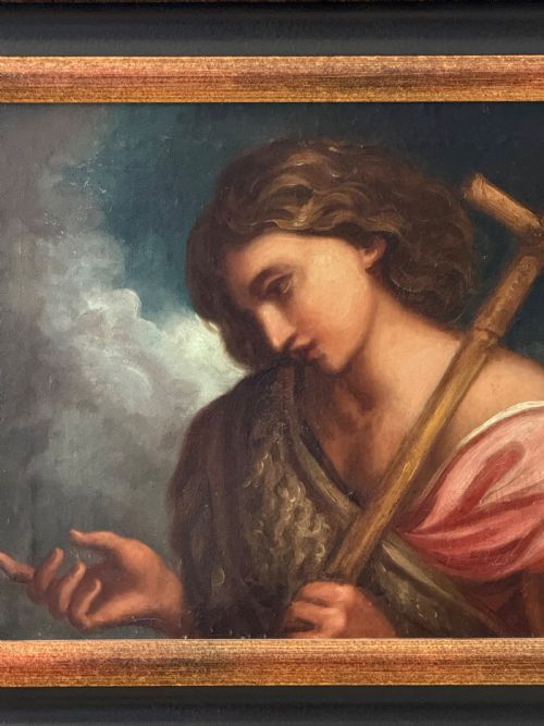 fig 1. An 18th-century oil painting depicting Saint John the Baptist holding a reed cross, presented in an ebonised wooden frame with gilt moulding.