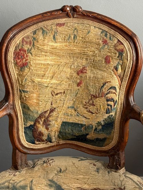 fig 1. A pair of late eighteenth-century Louis XV style carved wooden fauteuil armchairs upholstered in floral Aubusson tapestry featuring cabriole legs and curved armrests.