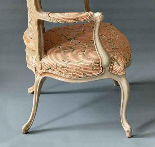 fig 1. An antique French Hepplewhite armchair featuring a distressed grey-painted carved frame and terracotta striped silk upholstery with leaf embroidery.