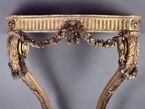 fig 1. A 19th-century French carved giltwood console table base featuring a fluted apron decorated with floral festoons and supported by curved cabriole legs.