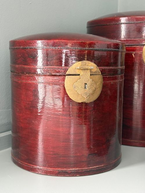fig 1. A set of four graduated cylindrical red lacquered wooden boxes featuring brass latch mountings on the front.