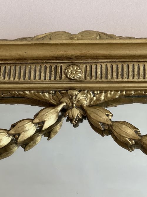 fig 1. A large 19th-century rectangular giltwood overmantel mirror featuring an inner arched frame adorned with hanging laurel leaf festoons and classical fluted mouldings.