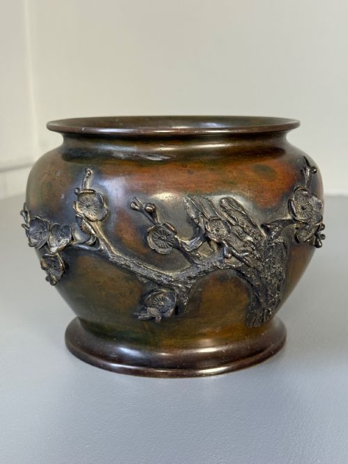 fig 2. A pair of dark bronze Meiji period jardinieres featuring high-relief cast decorations of blooming plum blossom branches.