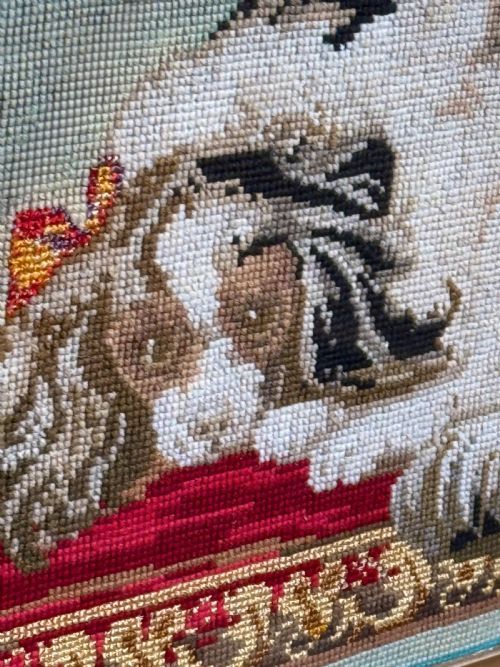 fig 1. A 19th-century rectangular Berlin woolwork embroidery featuring a King Charles spaniel curled on a red patterned cushion, set within a wide burr maple frame.