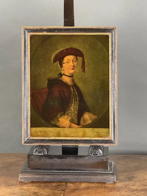fig 2. An 18th-century reverse-painted glass mezzotint portrait depicting a woman in a velvet bonnet and cloak within an ebonised and gilt frame.