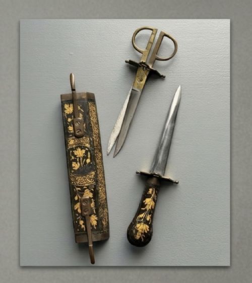 fig 1. A 19th-century Persian Qajar lacquered papier-mache dual sheath featuring gold leaf foliage, housing a dagger and a pair of brass-handled calligraphic scissors.