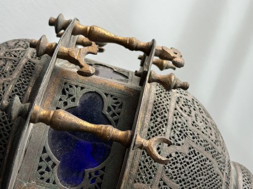 fig 2. A 19th-century Moorish style hanging lantern made of intricate pierced brass with small balusters and inset cobalt blue glass panels.
