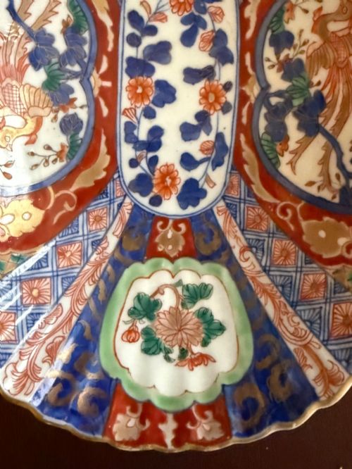 fig 2. An oblong 19th-century Japanese Imari porcelain dish with scalloped edges, decorated with hand-painted cobalt blue, orange, green, and gold floral and bird patterns.