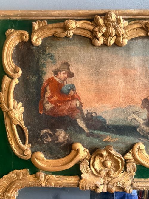 fig 1. An eighteenth-century style French Rococo trumeau mirror featuring a painted green timber frame with carved gilded scrollwork surrounding an upper landscape painting and a lower rectangular mirror plate.